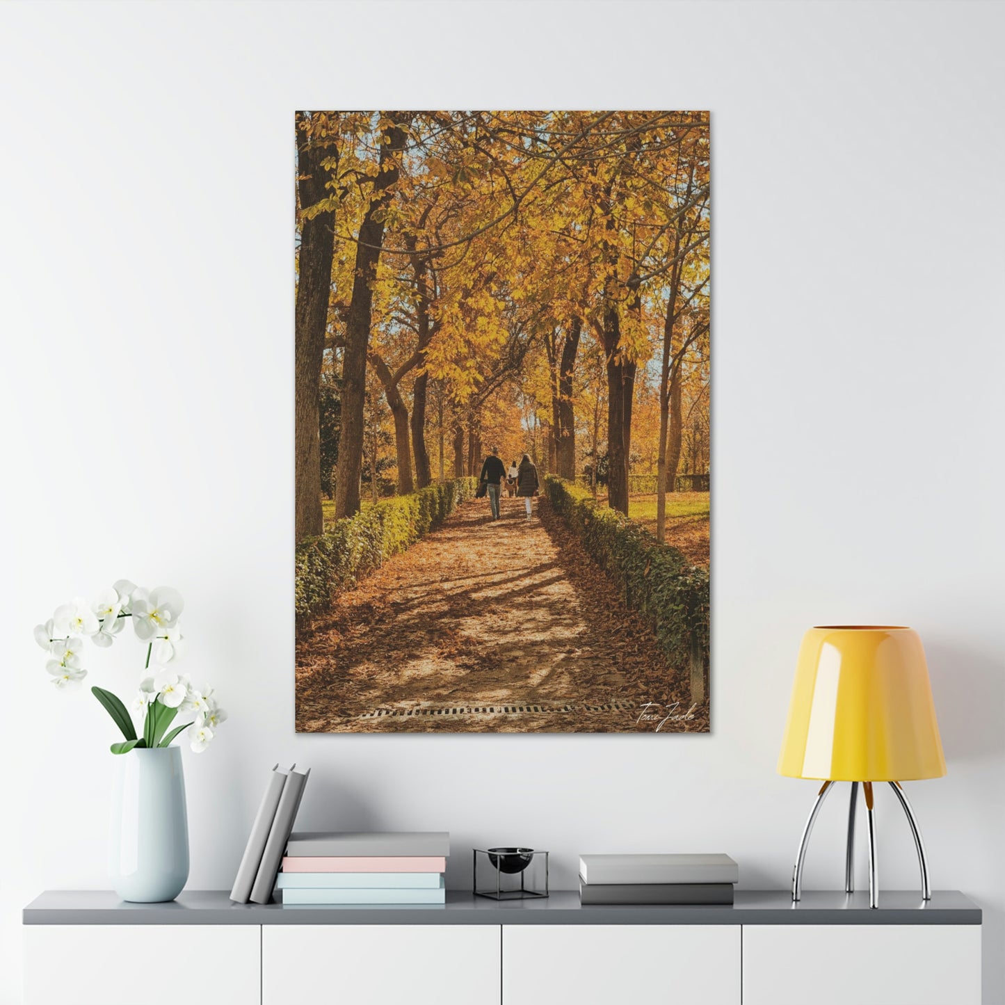 Our fall wall art in Spain is very colorful and vibrant. A couple is walking on the park trail with other families in front, the bright yellow leaves surrounding them. This canvas is a size 32 x 48.